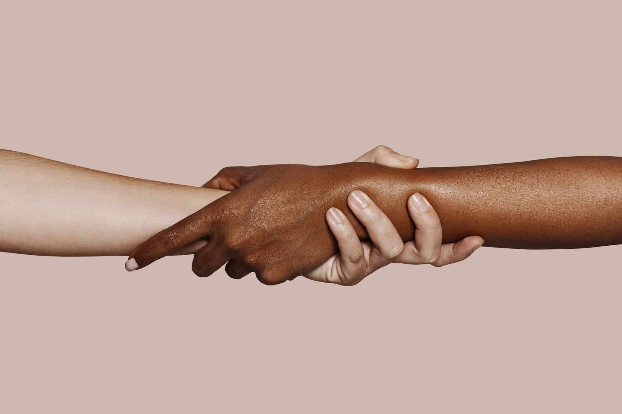 Close up multiracial black and white hands holding each other