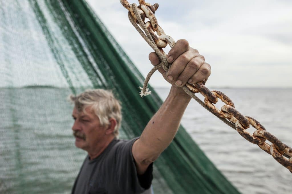Commercial fisherman holding rusty chain