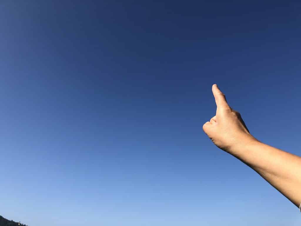 Finger is pointing blue sky background