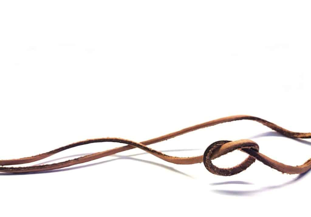 Less is more, minimalism. A loose knot on a leather string in an airy composition. Solution