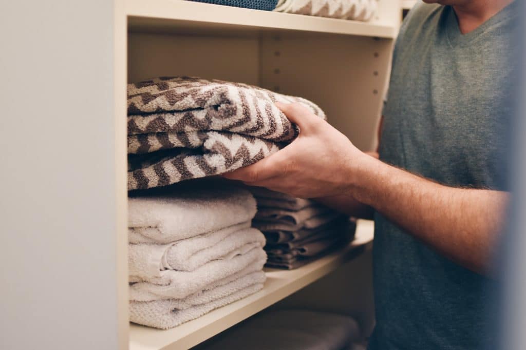 Organizing folded towels on the shelves in the towels closet