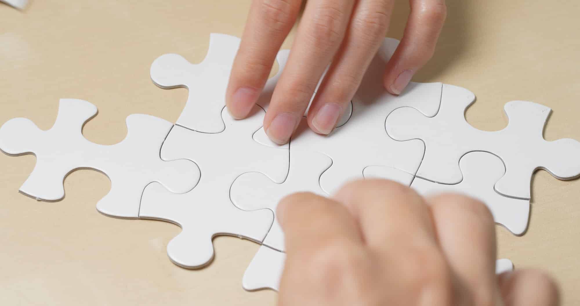 Teamwork, concept, completing white puzzle together